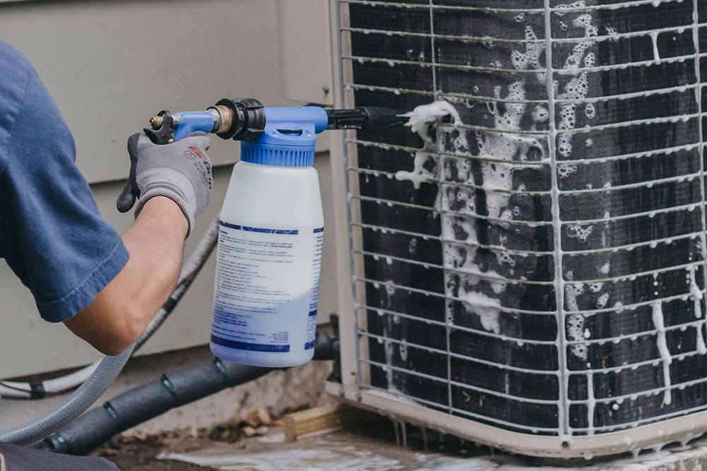 man cleaning ac unit