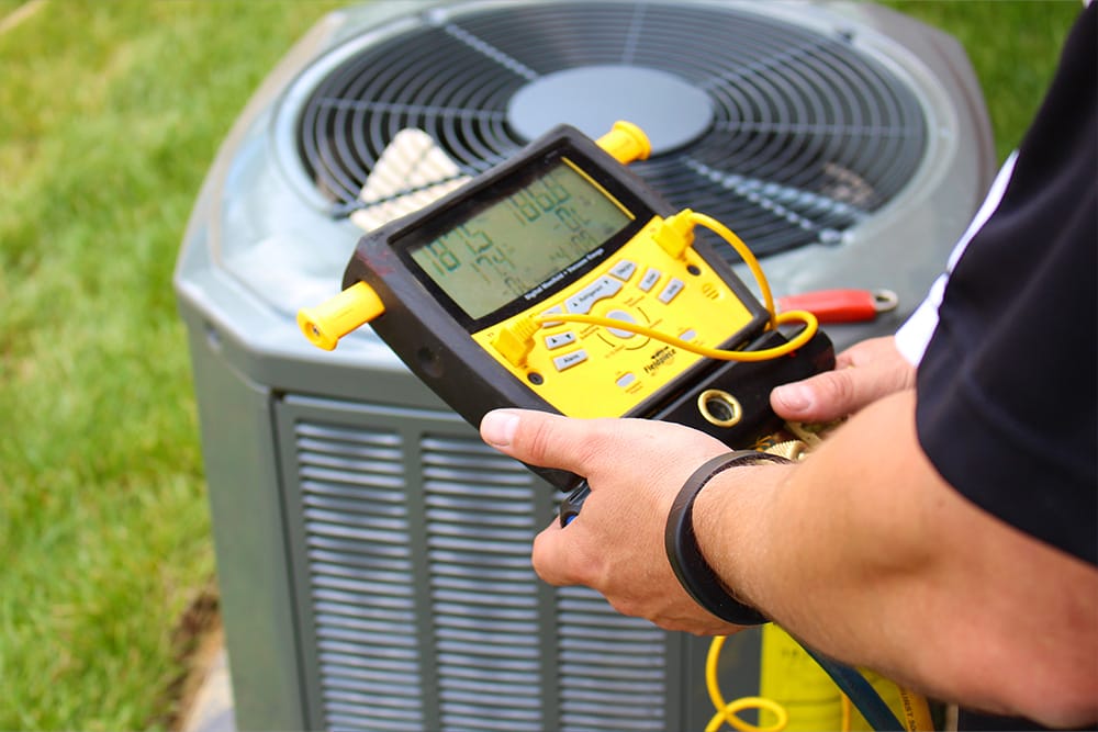 HVAC technician testing air conditioner performance during replacement service