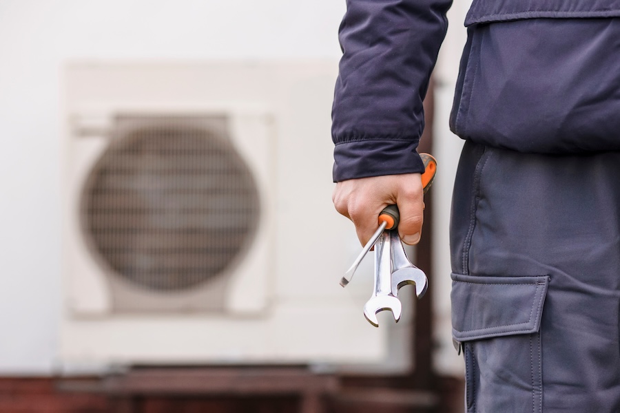 repairman working on heat pump